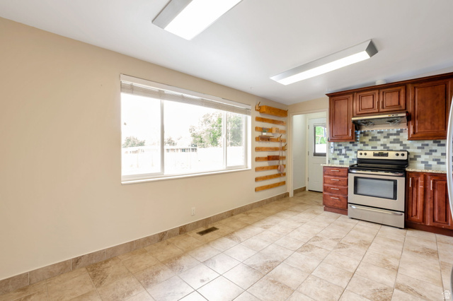 447 550 South Bountiful, UT 84010 - Photo 6 of 25 Kitchen featuring wood-finish cabinetry, stainless steel range, and a mosaic tile backsplash
