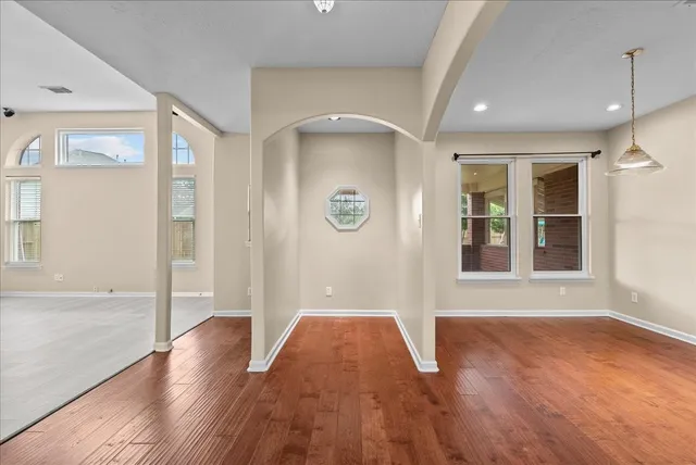 a dining room with furniture a window and wooden floor