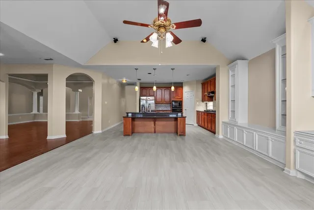 a living room with furniture a ceiling fan and a flat screen tv