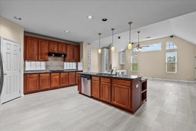 a kitchen with stainless steel appliances granite countertop a refrigerator and a sink
