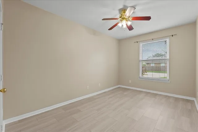 a view of a livingroom with a chair and ceiling fan