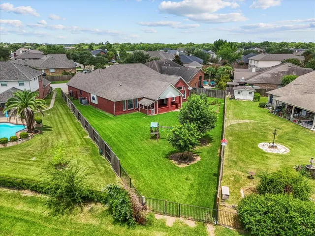 an aerial view of residential houses with outdoor space and trees