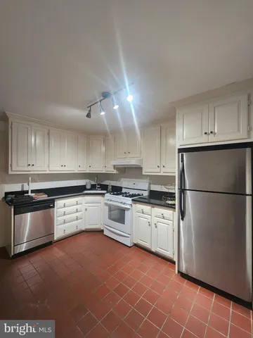 a kitchen with granite countertop stainless steel appliances and white cabinets