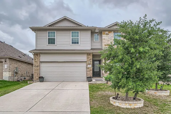 a front view of a house with a yard and garage