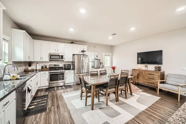 a kitchen with stainless steel appliances a stove a sink a microwave a refrigerator and cabinets