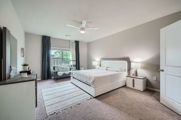 a bedroom with a bed and a large window