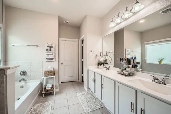 a bathroom with a double vanity sink a toilet a mirror and shower
