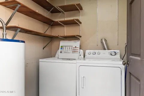 a bedroom with a bed painting on wall and a large window