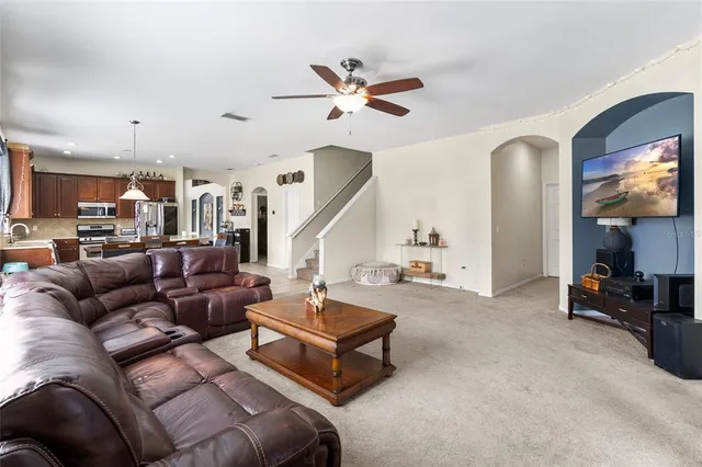 a living room with furniture and a ceiling fan