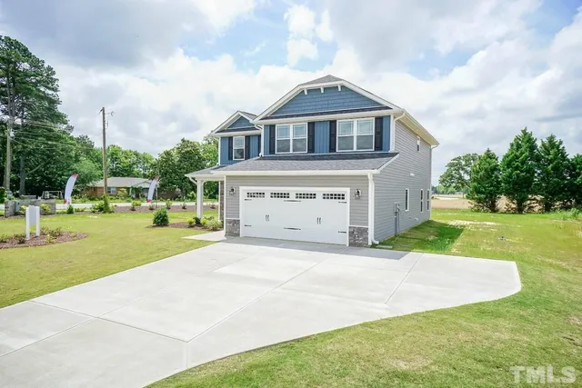 a front view of a house with a yard and trees