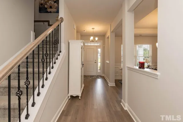 a view of a hallway with wooden floor and staircase