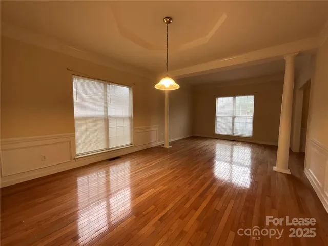 a view of a room with wooden floor and windows