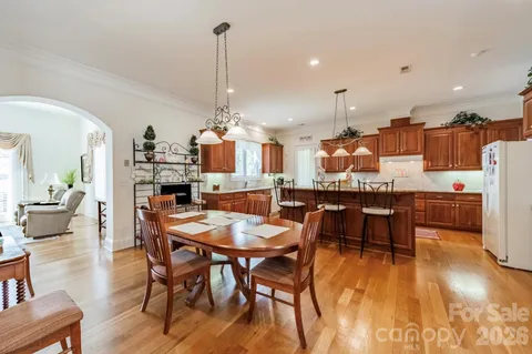 a view of a dining room and livingroom with furniture wooden floor a chandelier