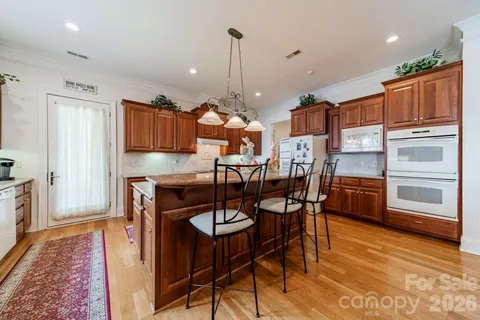 a kitchen with stainless steel appliances kitchen island granite countertop a refrigerator and microwave