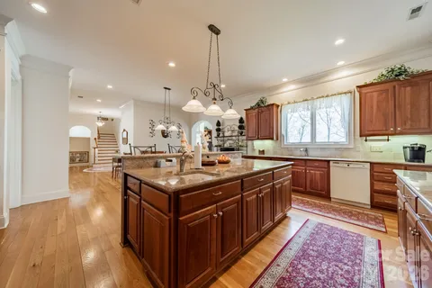 a kitchen with kitchen island granite countertop a sink and a stove