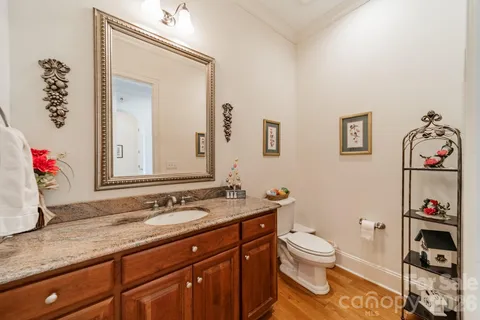 a bathroom with a granite countertop sink a toilet and a mirror
