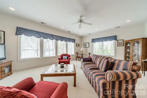 a living room with furniture ceiling fan and a wooden floor
