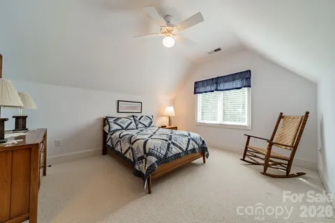 a bedroom with a bed a couch and dresser