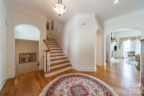 a view of a livingroom with wooden floor and stairs