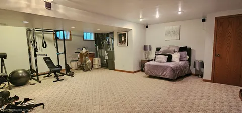 a bedroom with furniture a mirror and gym equipment