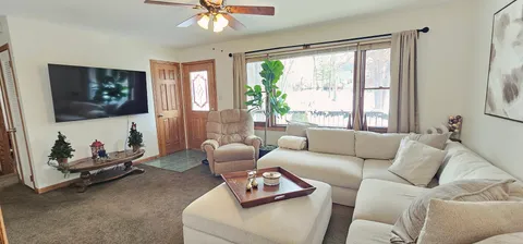 a living room with furniture a flat screen tv and a large window