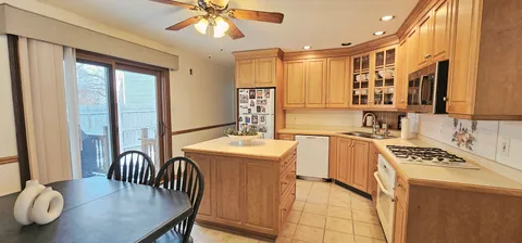 a kitchen with stainless steel appliances granite countertop a stove top oven a sink a dining table and chairs