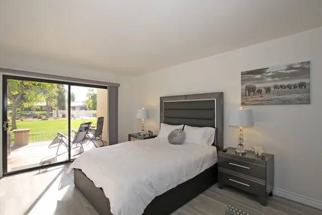 a bedroom with a bed and a large window