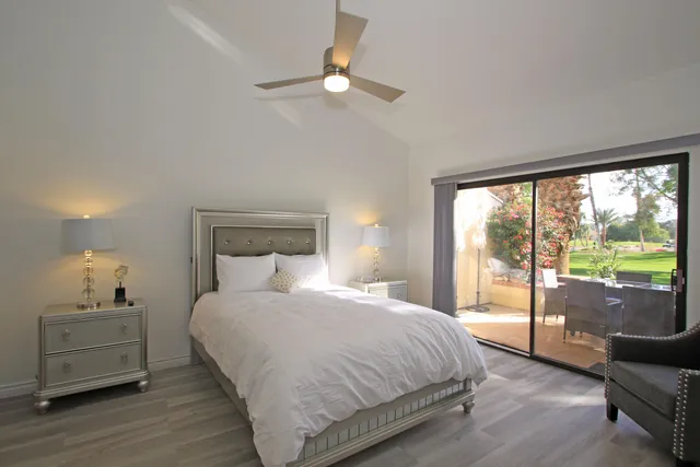 a bedroom with a balcony a bed and wooden floor