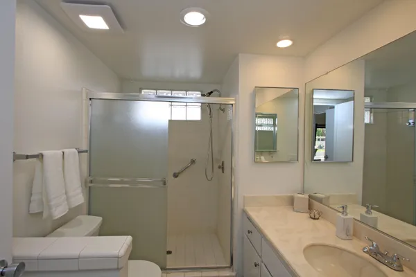 a bathroom with a granite countertop sink toilet and shower