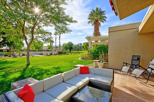 a view of a patio with couches table and chairs with a yard
