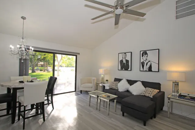 a living room with furniture a window and a chandelier