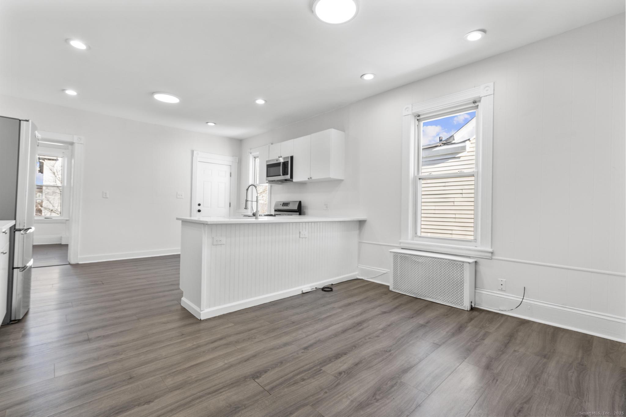 394 Gregory Street, Unit 4 Bridgeport, CT 06604 - Photo 12 of 23 a room with wooden floors and white walls