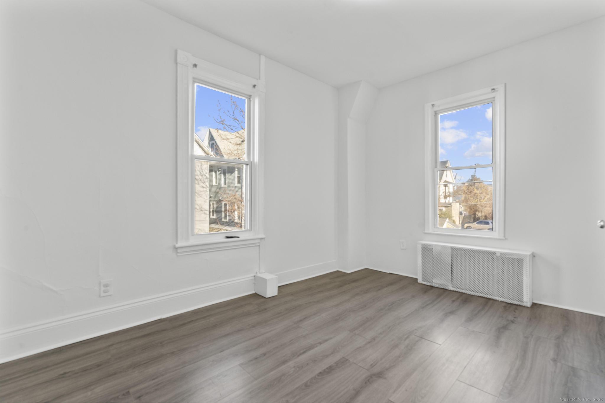 394 Gregory Street, Unit 4 Bridgeport, CT 06604 - Photo 16 of 23 a view of an empty room with wooden floor and a window