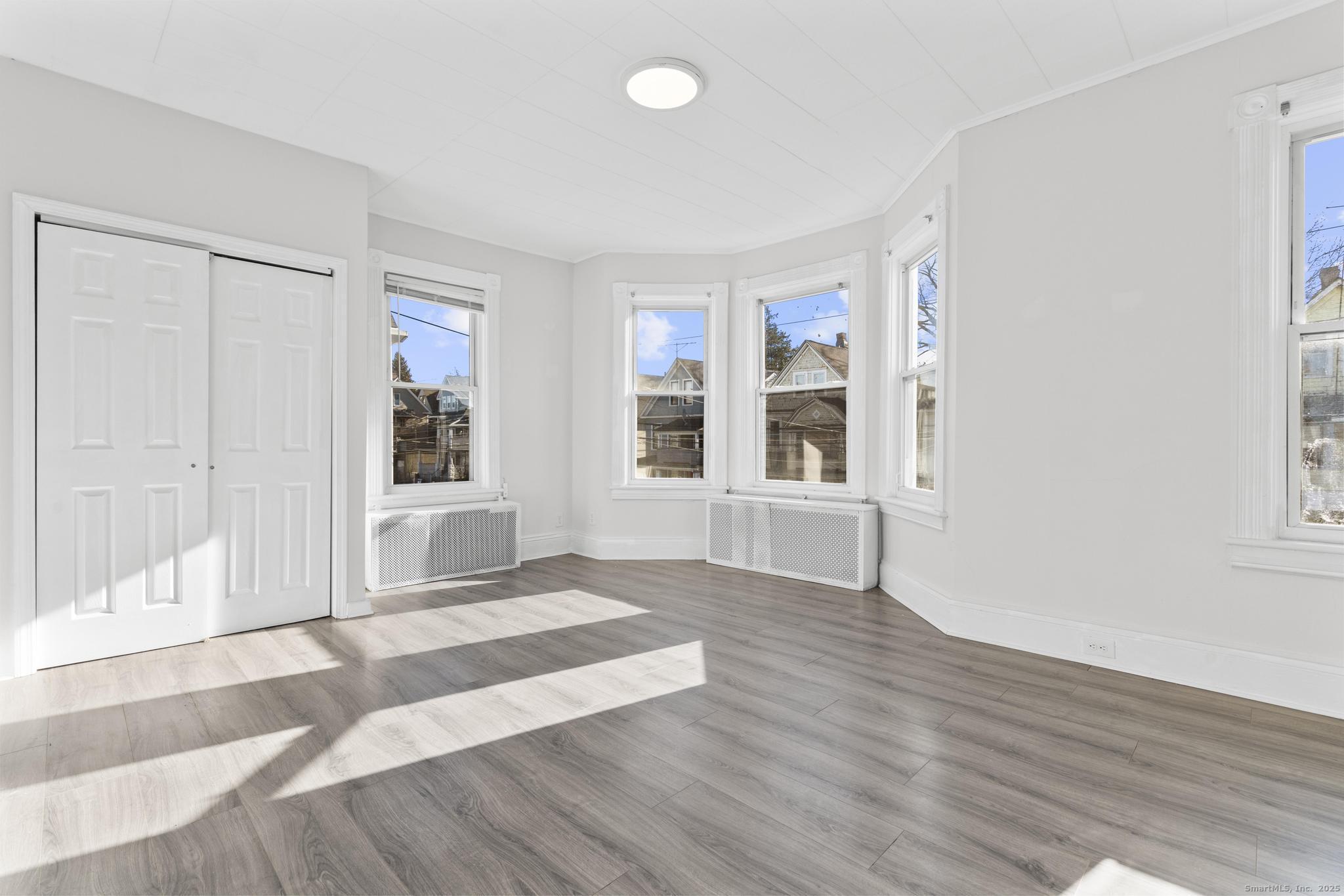 394 Gregory Street, Unit 4 Bridgeport, CT 06604 - Photo 19 of 23 a view of an empty room with wooden floor and a window