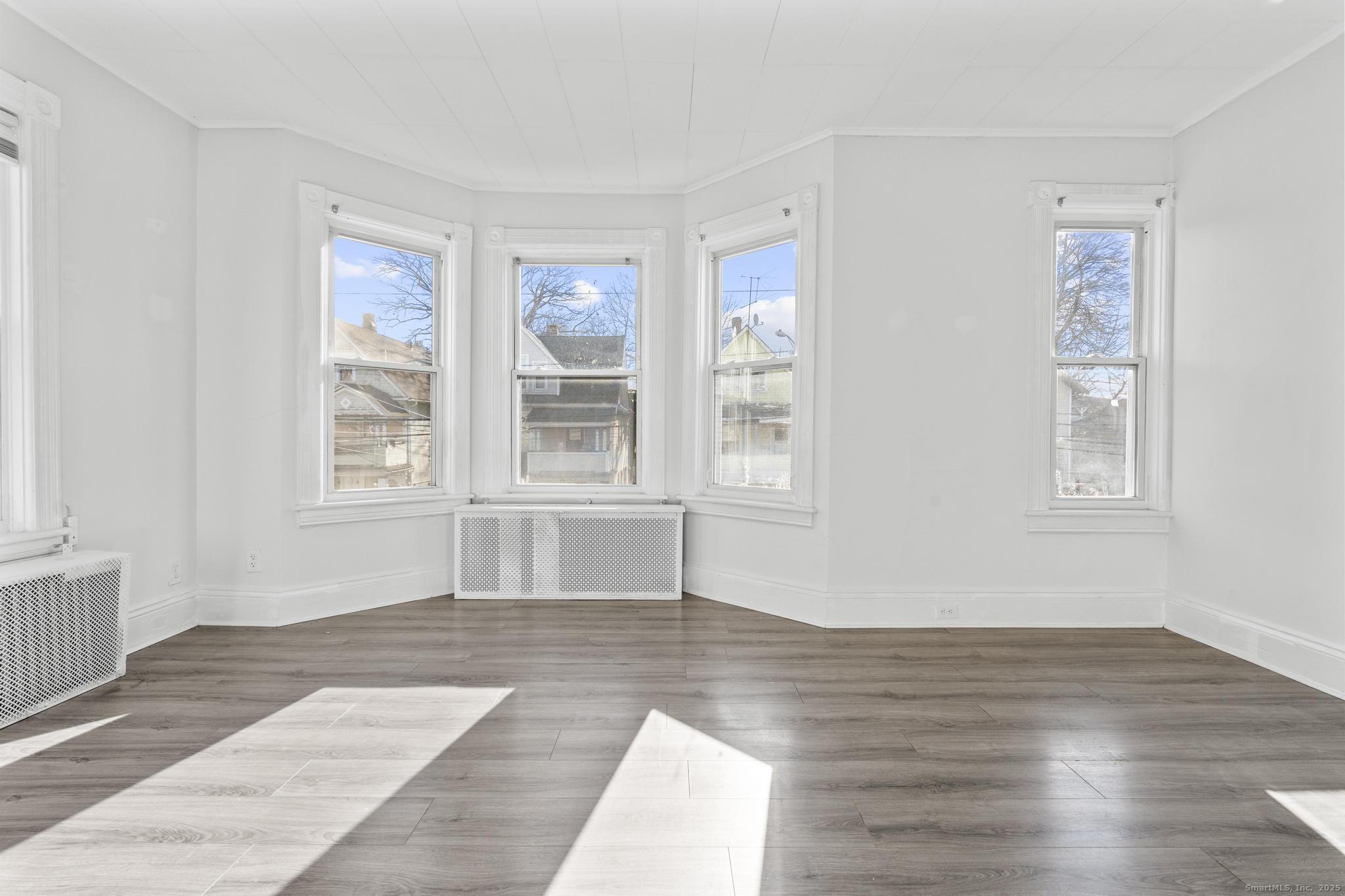 394 Gregory Street, Unit 4 Bridgeport, CT 06604 - Photo 20 of 23 a view of an empty room with wooden floor and a window