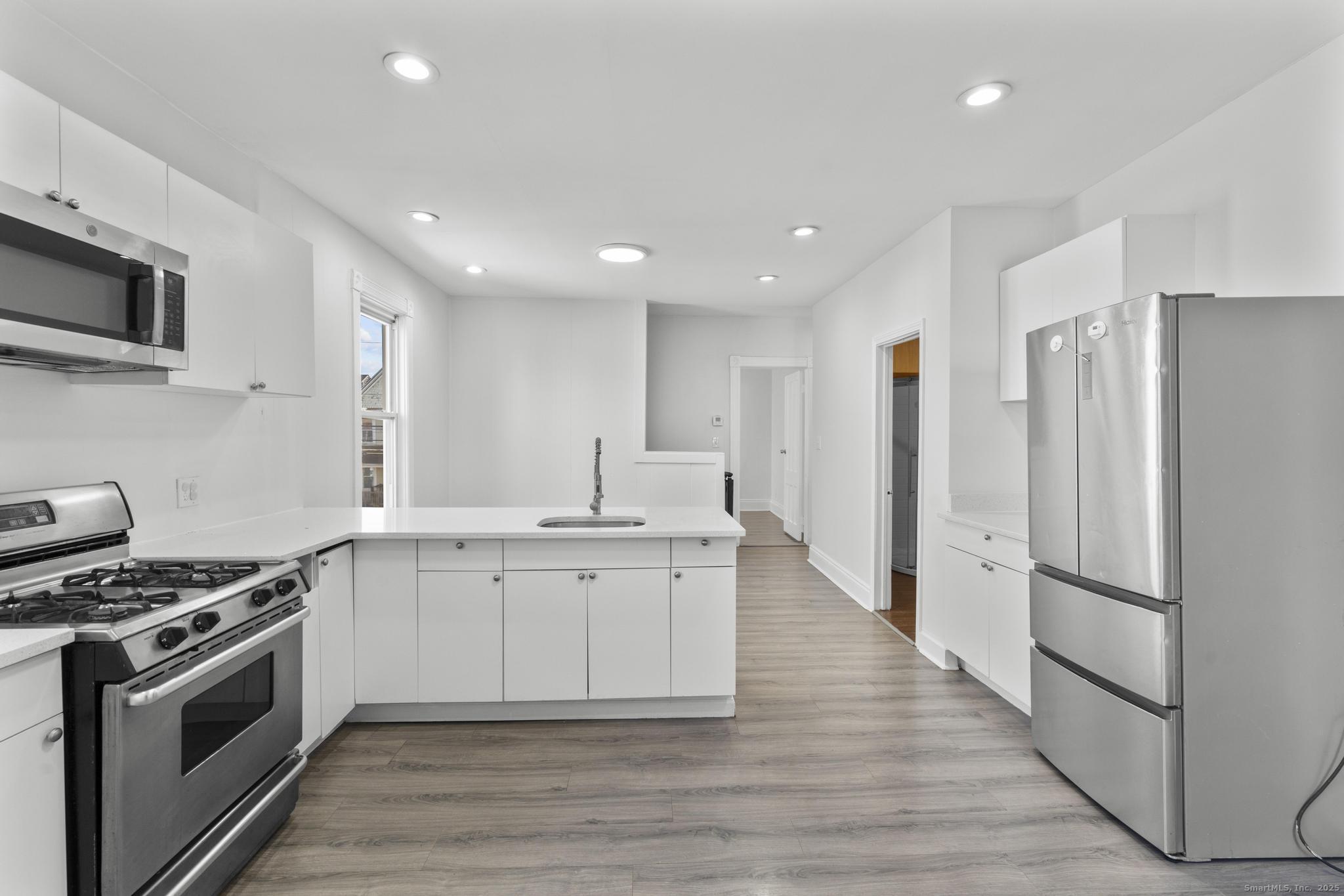 394 Gregory Street, Unit 4 Bridgeport, CT 06604 - Photo 5 of 23 a large kitchen with stainless steel appliances granite countertop a stove a sink and a refrigerator