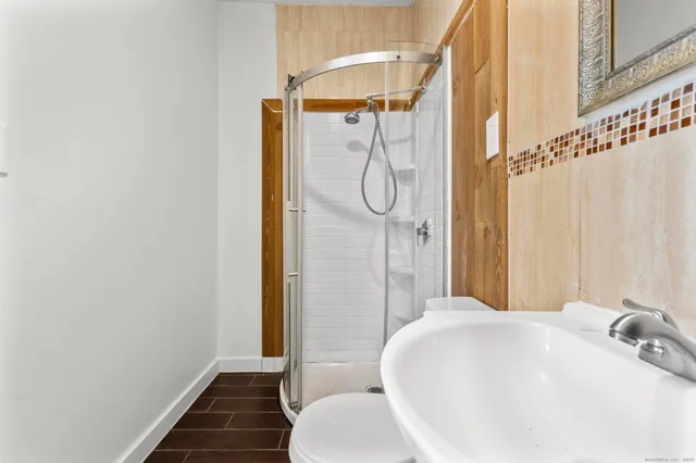 a bathroom with a white tub shower and sink