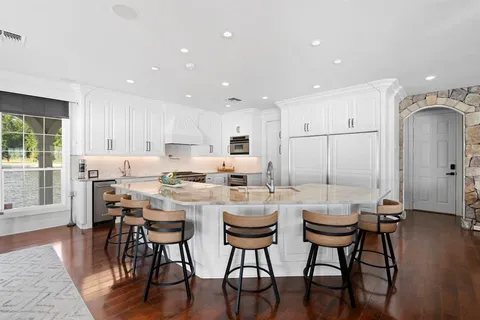 a dining room with stainless steel appliances kitchen island granite countertop a dining table chairs and view living room