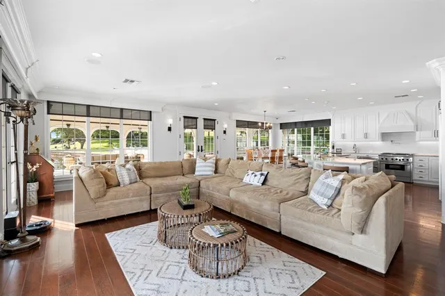 a living room with furniture wooden floor and a large window