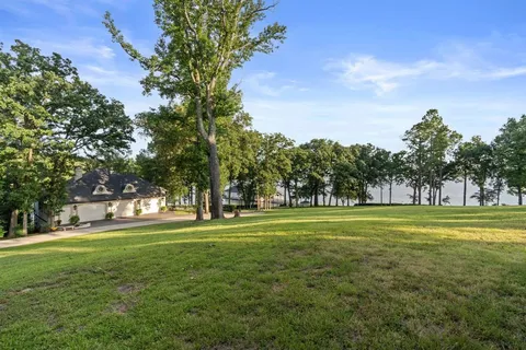 a big yard with lots of trees in the background