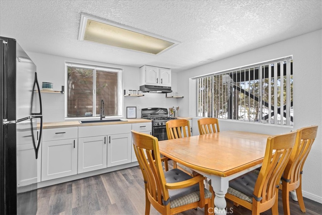 113 East Fairway Boulevard Big Bear City, CA 92314 - Photo 26 of 36 a kitchen with stainless steel appliances granite countertop a stove a refrigerator a sink a dining table and chairs