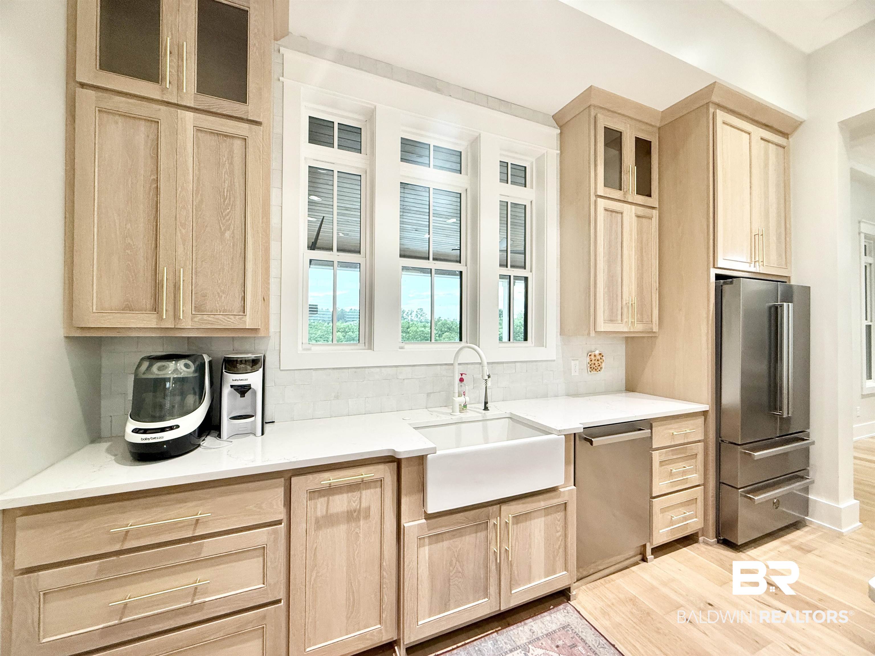 21767 Gallery Boulevard Fairhope, AL 36532 - Photo 16 of 74 Kitchen with light brown cabinetry, stainless steel appliances, light wood-style floors, and tasteful backsplash