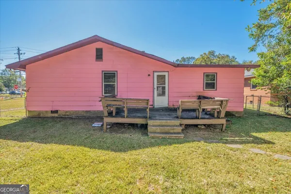 a backyard of a house with barbeque oven table and chairs