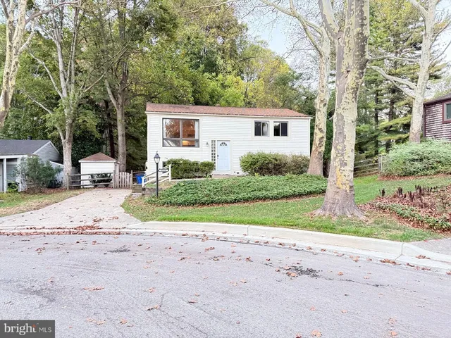 a view of a house with a yard and large tree