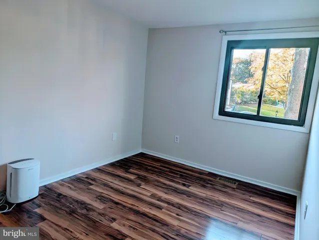 a view of a room with wooden floor and small window