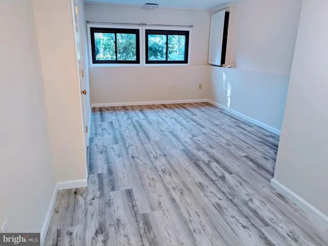 a view of a room with wooden floor and a bathroom