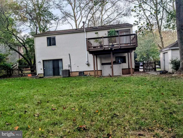 a view of a backyard with plants and large trees