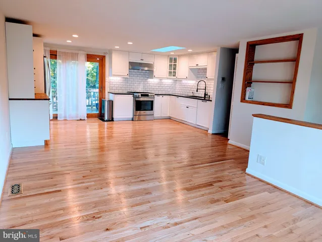 a large kitchen with stainless steel appliances granite countertop a refrigerator and a stove top oven