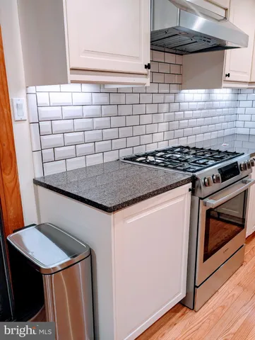 a kitchen with granite countertop a stove a sink and a microwave
