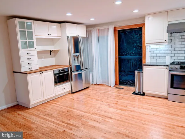 a kitchen with stainless steel appliances kitchen island granite countertop a refrigerator and a stove